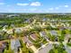 An aerial view shows a residence with lush landscaping, a nearby pond, and green spaces at 4954 Newport News Cir, Lakewood Ranch, FL 34211
