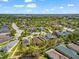 An aerial view shows a neighborhood with mature trees, ponds, and residences at 4954 Newport News Cir, Lakewood Ranch, FL 34211