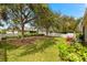 Lush backyard featuring mature trees, a white picket fence, and well-maintained lawn at 4954 Newport News Cir, Lakewood Ranch, FL 34211