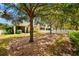 Secluded backyard featuring mature trees, a patio, and a charming white picket fence at 4954 Newport News Cir, Lakewood Ranch, FL 34211