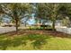 Expansive backyard with lush lawn, mature trees, and white picket fence at 4954 Newport News Cir, Lakewood Ranch, FL 34211