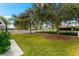 Picturesque backyard with mature trees, a white picket fence, and lush landscaping at 4954 Newport News Cir, Lakewood Ranch, FL 34211