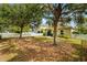 Private backyard featuring a white picket fence, mature trees, and lush landscaping at 4954 Newport News Cir, Lakewood Ranch, FL 34211