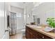 Bathroom features a dark vanity with large mirror and shower-tub combo with white tile surround at 4954 Newport News Cir, Lakewood Ranch, FL 34211