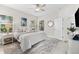 Bright bedroom with natural light, ceiling fan, and a gray area rug on white tile floors at 4954 Newport News Cir, Lakewood Ranch, FL 34211