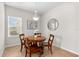 Bright dining area with a wooden table, four chairs, neutral decor, and natural light at 4954 Newport News Cir, Lakewood Ranch, FL 34211
