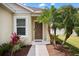Inviting front entrance with a brown door, walkway, and lush tropical landscaping at 4954 Newport News Cir, Lakewood Ranch, FL 34211