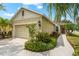 Charming single-story home featuring a landscaped front yard with flowers and an attached garage at 4954 Newport News Cir, Lakewood Ranch, FL 34211