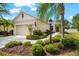 Landscaped front yard featuring a charming one-story home and driveway with an attached garage at 4954 Newport News Cir, Lakewood Ranch, FL 34211