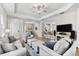 Open-concept living room featuring neutral sofas, accent pillows, and view to the kitchen at 4954 Newport News Cir, Lakewood Ranch, FL 34211