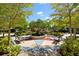 A community park with benches surrounds a raised circular garden under shady trees at 4954 Newport News Cir, Lakewood Ranch, FL 34211