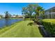 Beautiful backyard features a lush lawn and a serene lake view with mature trees and landscaping at 5087 Timber Chase Way, Sarasota, FL 34238