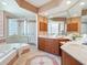 Modern bathroom featuring double vanities, large mirror, soaking tub, and separate shower at 5087 Timber Chase Way, Sarasota, FL 34238