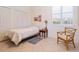 A simple bedroom with tile flooring, a white wall, and a small window at 5087 Timber Chase Way, Sarasota, FL 34238