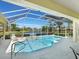 Inviting screened-in pool and hot tub area with comfortable lounge chairs overlooking a scenic lake at 5087 Timber Chase Way, Sarasota, FL 34238