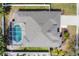 Aerial view of a home featuring a screened in pool, neutral roof, large driveway, and manicured landscaping at 5806 43Rd E Ct, Bradenton, FL 34203
