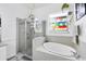 Bright bathroom featuring a glass shower and tiled soaking tub below a colorful stained glass window at 5806 43Rd E Ct, Bradenton, FL 34203