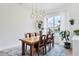 Bright dining room featuring a large window, modern chandelier and wood table with seating for six at 5806 43Rd E Ct, Bradenton, FL 34203