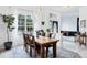 Bright dining room featuring a large window, modern chandelier, wood table, and view to the front door at 5806 43Rd E Ct, Bradenton, FL 34203