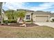 Charming home with a manicured lawn and mature landscaping, including decorative stone and lovely palm trees at 5806 43Rd E Ct, Bradenton, FL 34203