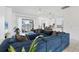 Spacious living room area with a large blue sectional, bright lighting, and view of the kitchen and lanai at 5806 43Rd E Ct, Bradenton, FL 34203
