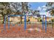 Community swingset next to well-maintained homes with large trees at 5806 43Rd E Ct, Bradenton, FL 34203