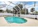Inviting screened-in pool area with lush landscaping and a concrete patio under a bright blue sky at 5806 43Rd E Ct, Bradenton, FL 34203