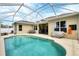 Backyard screened-in pool area with tanning ledge, outdoor seating, a grill and covered patio at 5806 43Rd E Ct, Bradenton, FL 34203