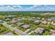 Wide aerial shot of a neighborhood with lush landscaping, a pond, and well-maintained homes and streets at 604 166Th E St, Bradenton, FL 34212