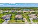 Aerial view of a home with lush landscaping, a backyard pool, and a tranquil pond nearby at 604 166Th E St, Bradenton, FL 34212