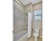 Cozy bathroom with a shower-tub combo, and toilet. Features neutral colors and natural light at 604 166Th E St, Bradenton, FL 34212