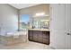 Primary bathroom featuring soaking tub, vanity with marble countertop and ample natural light at 604 166Th E St, Bradenton, FL 34212