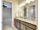 Bathroom featuring granite countertops, double sinks and mirror with access to the bedroom at 604 166Th E St, Bradenton, FL 34212