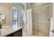 Bathroom featuring granite countertop, walk-in shower, and access to patio at 604 166Th E St, Bradenton, FL 34212