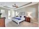 Spacious bedroom with stylish furnishings, tray ceiling, and view into an en-suite bathroom at 604 166Th E St, Bradenton, FL 34212