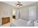 Cozy bedroom with neutral colors, ceiling fan, adjacent bathroom and dresser at 604 166Th E St, Bradenton, FL 34212
