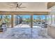 Covered patio featuring travertine floors and panoramic views of the screened in pool and lush landscaping at 604 166Th E St, Bradenton, FL 34212
