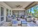 Relaxing covered lanai has comfortable seating area with tropical landscaping views through open screened windows at 604 166Th E St, Bradenton, FL 34212