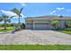Spacious driveway leading to a three-car garage with neat landscaping and palm trees at 604 166Th E St, Bradenton, FL 34212