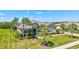 Well-manicured, light gray home featuring a tile roof, arched entryway, and lush landscaping at 604 166Th E St, Bradenton, FL 34212