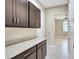Hallway with overhead cabinets and granite countertops leading to other rooms with tile flooring at 604 166Th E St, Bradenton, FL 34212