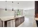 Modern kitchen features a large island with stone countertops, stainless steel appliances, and stylish pendant lighting at 604 166Th E St, Bradenton, FL 34212