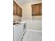Well-equipped laundry room featuring overhead storage cabinets and modern appliances for convenience at 604 166Th E St, Bradenton, FL 34212