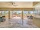Sunlit room with travertine floors, large windows offering backyard views, and a cozy spot for dining or entertaining at 604 166Th E St, Bradenton, FL 34212