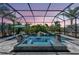 Screened-in pool with waterfall features, lush tropical landscaping, and a relaxing spa at 604 166Th E St, Bradenton, FL 34212
