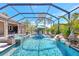 Stunning pool with waterfall and integrated spa, surrounded by tropical landscaping, and covered screened enclosure at 604 166Th E St, Bradenton, FL 34212