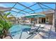 Inviting screened-in pool area with a spa, in-pool seating, and a relaxing outdoor space for leisure and entertainment at 604 166Th E St, Bradenton, FL 34212