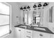Bright bathroom with double sink vanity, modern lighting, and large mirror at 617 Cervina S Dr, Venice, FL 34285