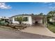 Charming home featuring a covered parking area, landscaped garden, and well-maintained lawn at 617 Cervina S Dr, Venice, FL 34285