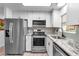 Updated kitchen boasts stainless steel appliances, granite countertops, and mosaic backsplash at 617 Cervina S Dr, Venice, FL 34285